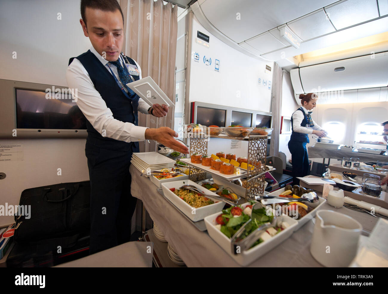 En Flight Crew sirviendo la cena gourmet en clase business sección de Turkish Airlines vuelo desde Estambul a Los Angeles, Foto de stock