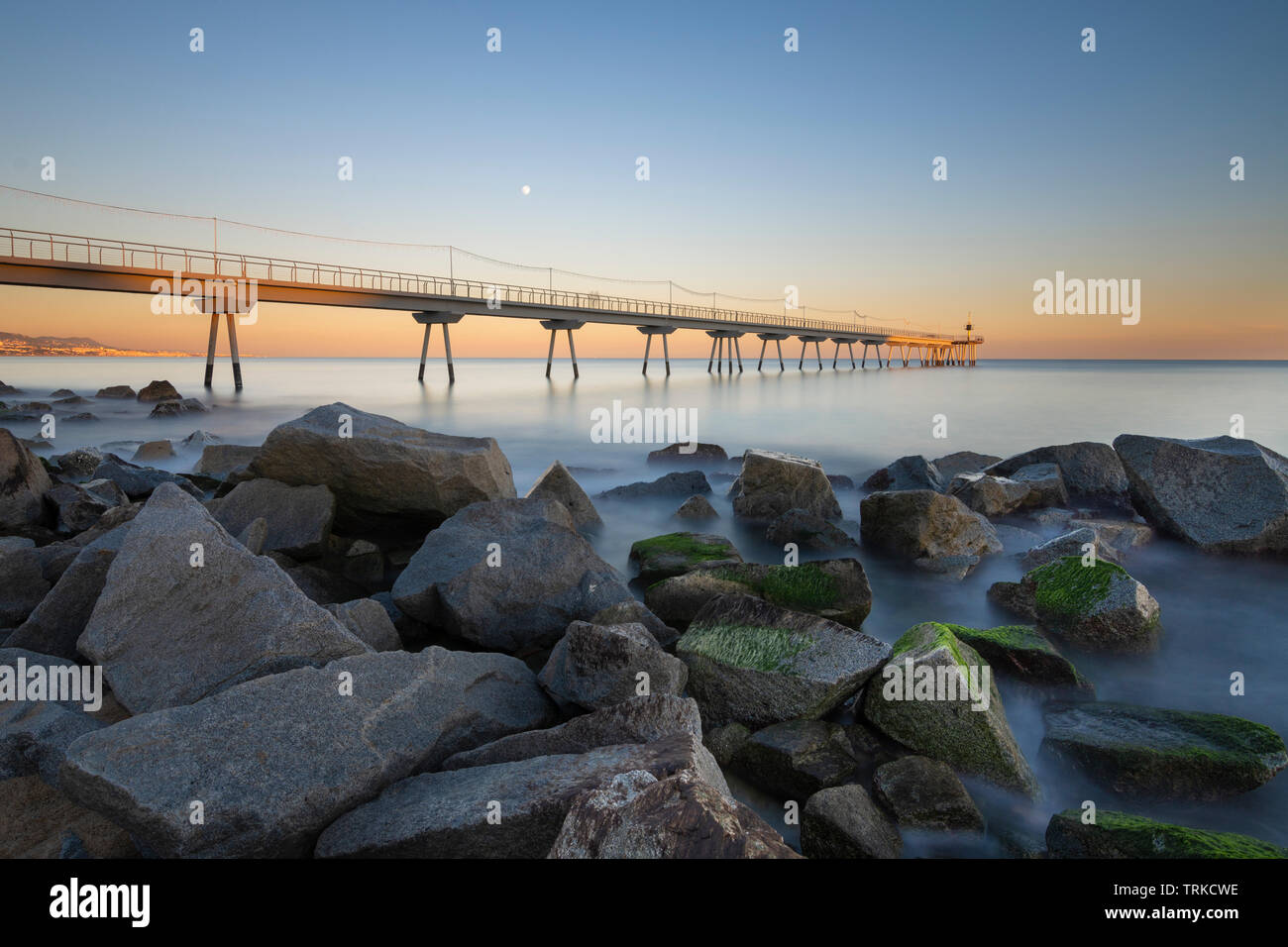 Puente en la playa al amanecer. Foto de stock