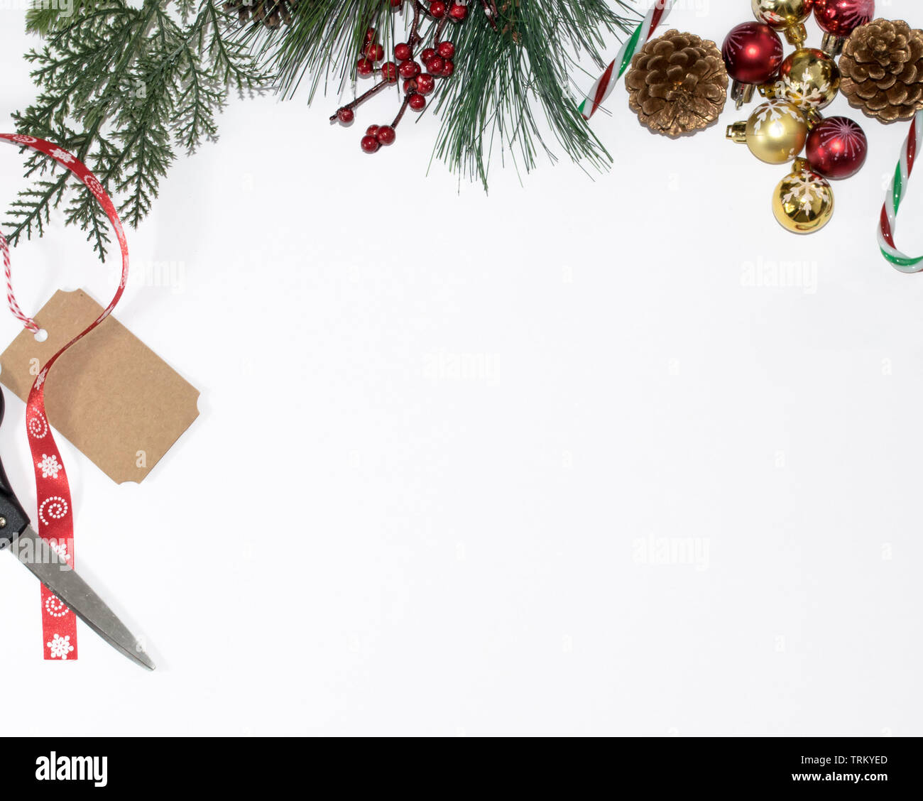 Fondo de navidad con ramas de árbol, ornamento bolas, cono de pino, bastones de caramelo, Etiquetas de regalo y cinta roja con tijeras, plana lay, vista superior con copia Foto de stock