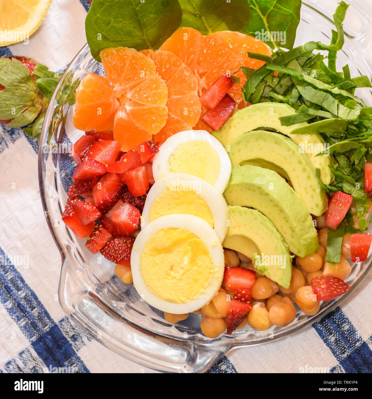 Ensalada de frutas y verduras frescas con huevos y aguacates en un tazón de vidrio, desayuno saludable, vista superior Foto de stock