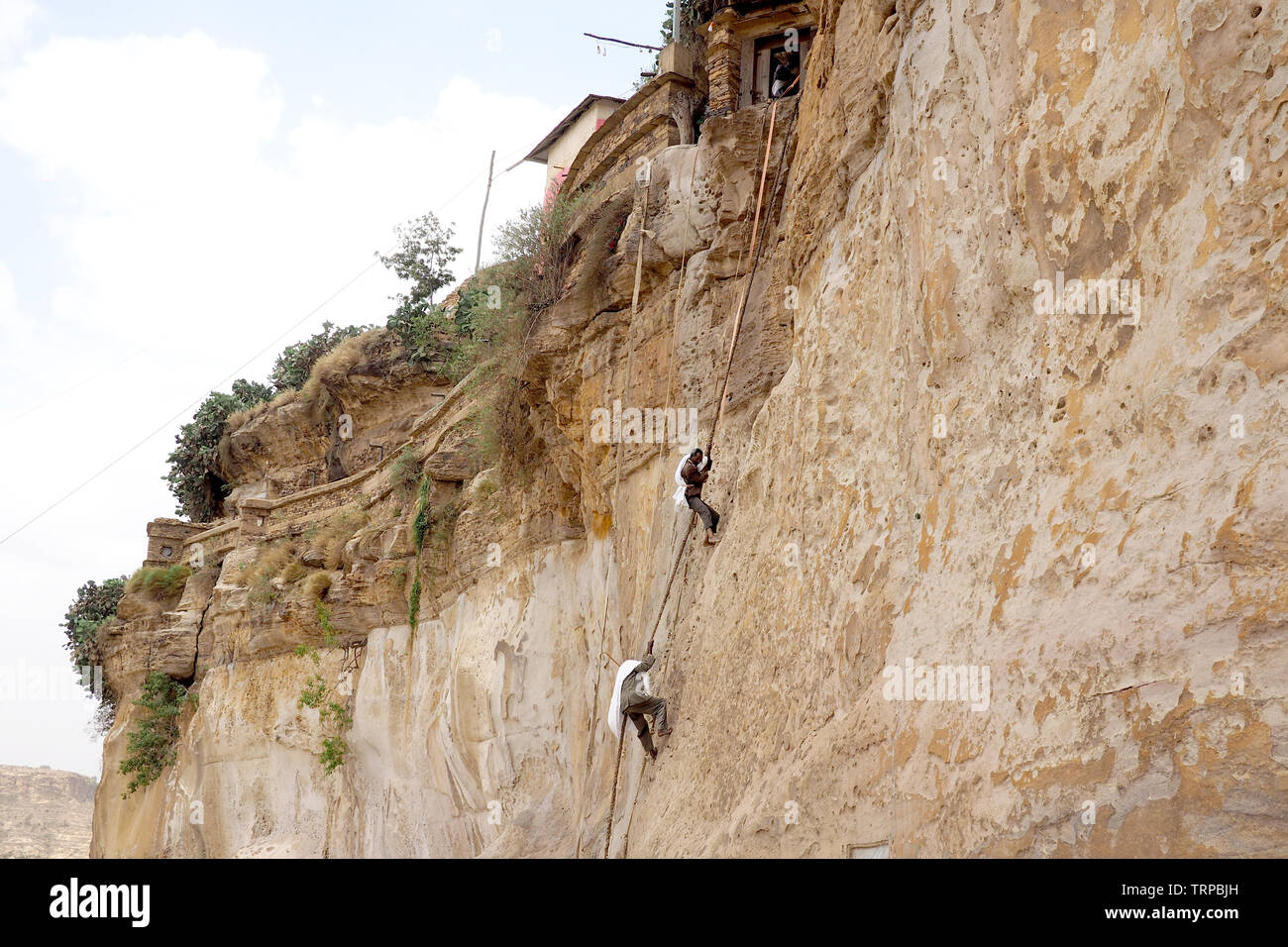 Los monjes escalar una pared de roca en el monasterio de Debre Damo, Etiopía Foto de stock