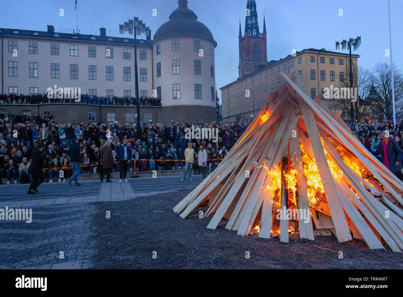 Montón de madera ardiendo y multitudes delante del palacio Wrangel celebrando Mayday vísperas vieja costumbre (St. Walpurgis). Riddarholmen, Gamla Stan, Estocolmo, Suecia Foto de stock