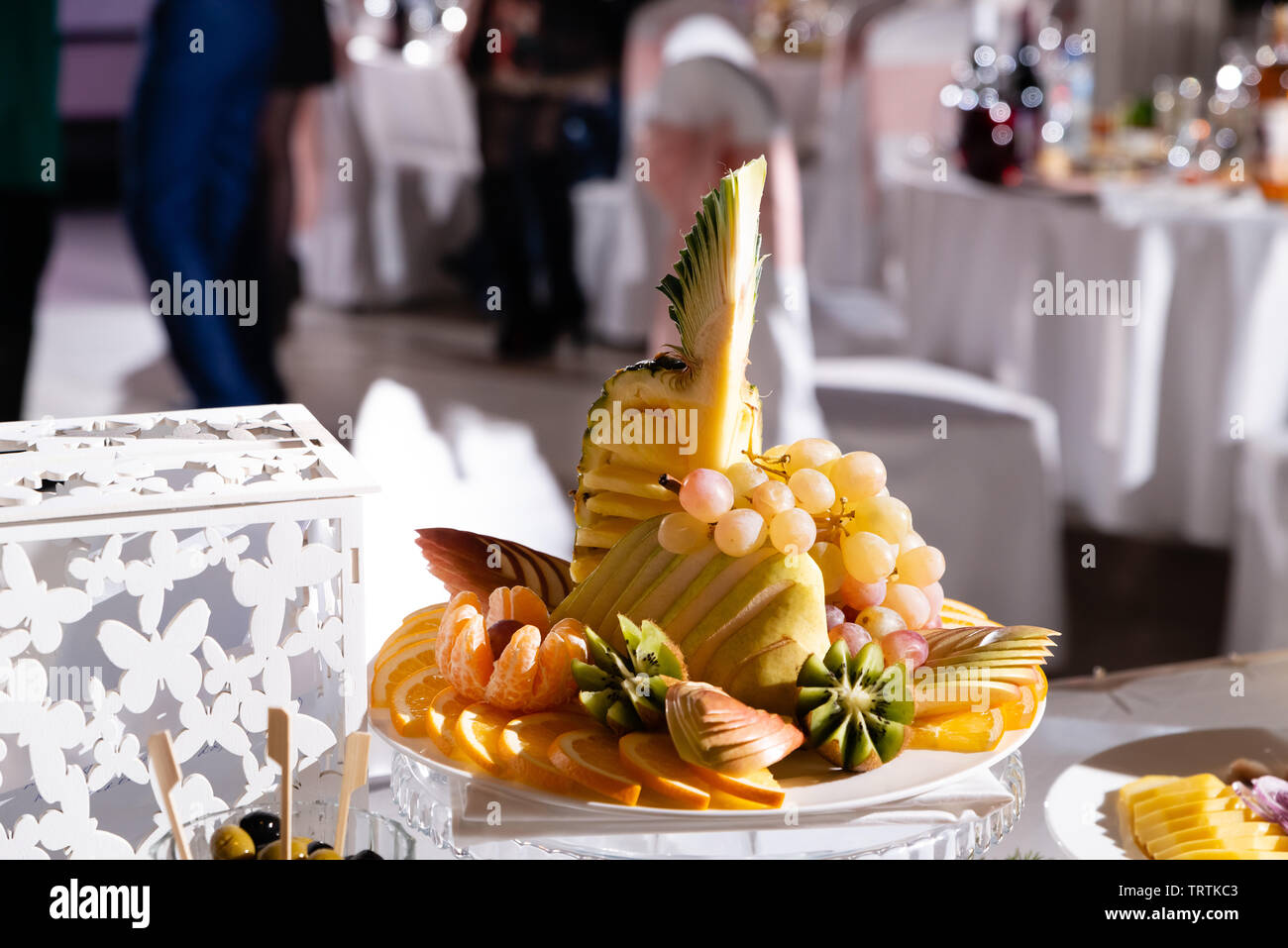 Un plato de fruta fresca en la mesa de banquete en el restaurante Foto de stock