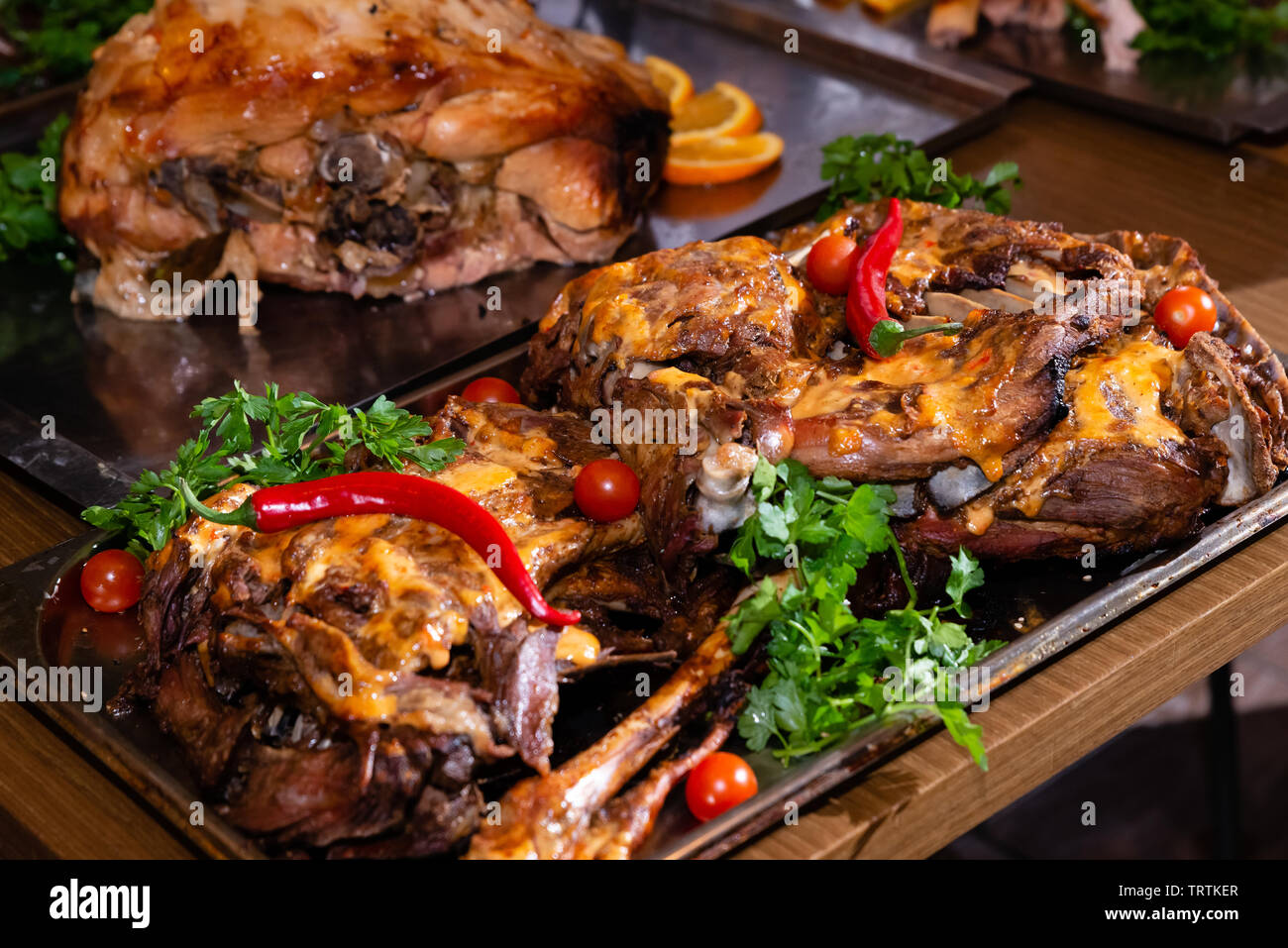 Articulación de lomo de cerdo asado en una bandeja metálica sobre la mesa en el restaurante que sirve Foto de stock