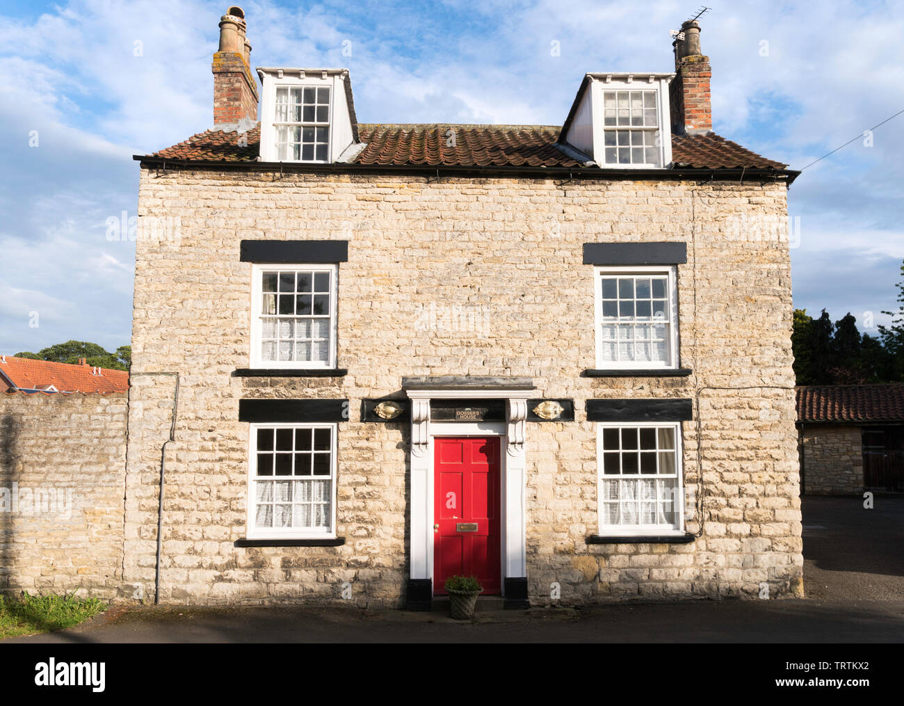 Grado II, se encuentra una casa de piedra, Dossers House, en la verde en Slingsby, North Yorkshire, Inglaterra, Reino Unido. Foto de stock
