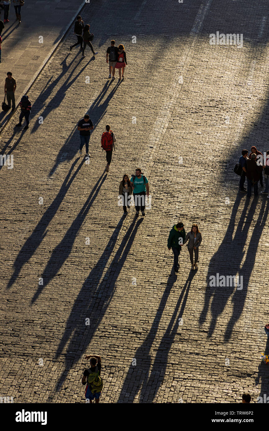 Los peatones arrojar sombras largas en la Plaza de Armas de adoquines a última hora de la tarde en Arequipa, Perú, América del Sur Foto de stock