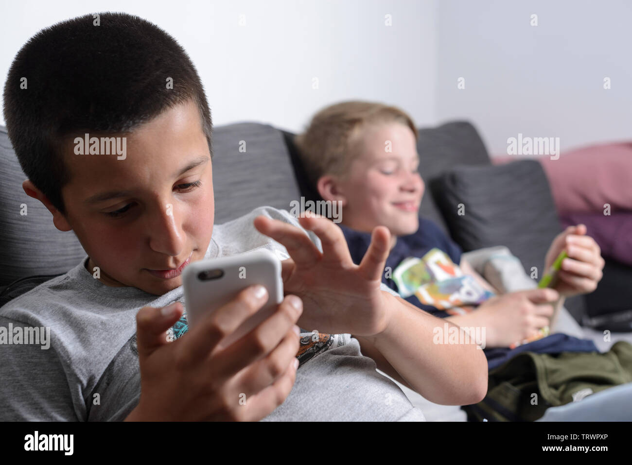 Schoolmates-Boys viendo videos en línea en sus teléfonos móviles Foto de stock