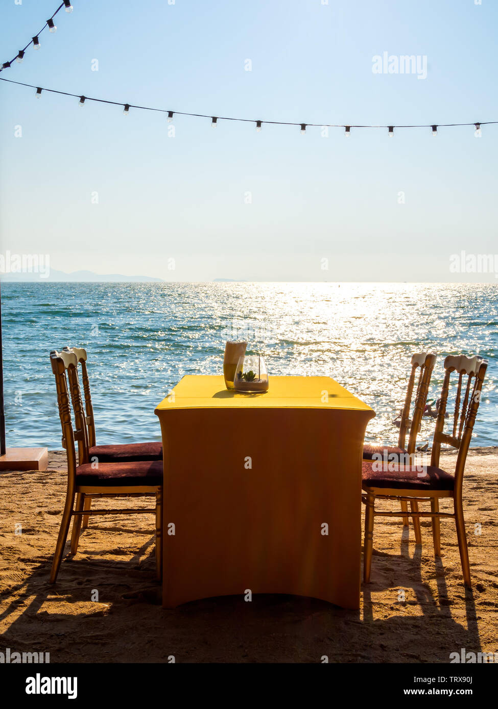 Mesa de comedor con cuatro sillas en la playa en el Seascape fondo estilo  vertical Fotografía de stock - Alamy