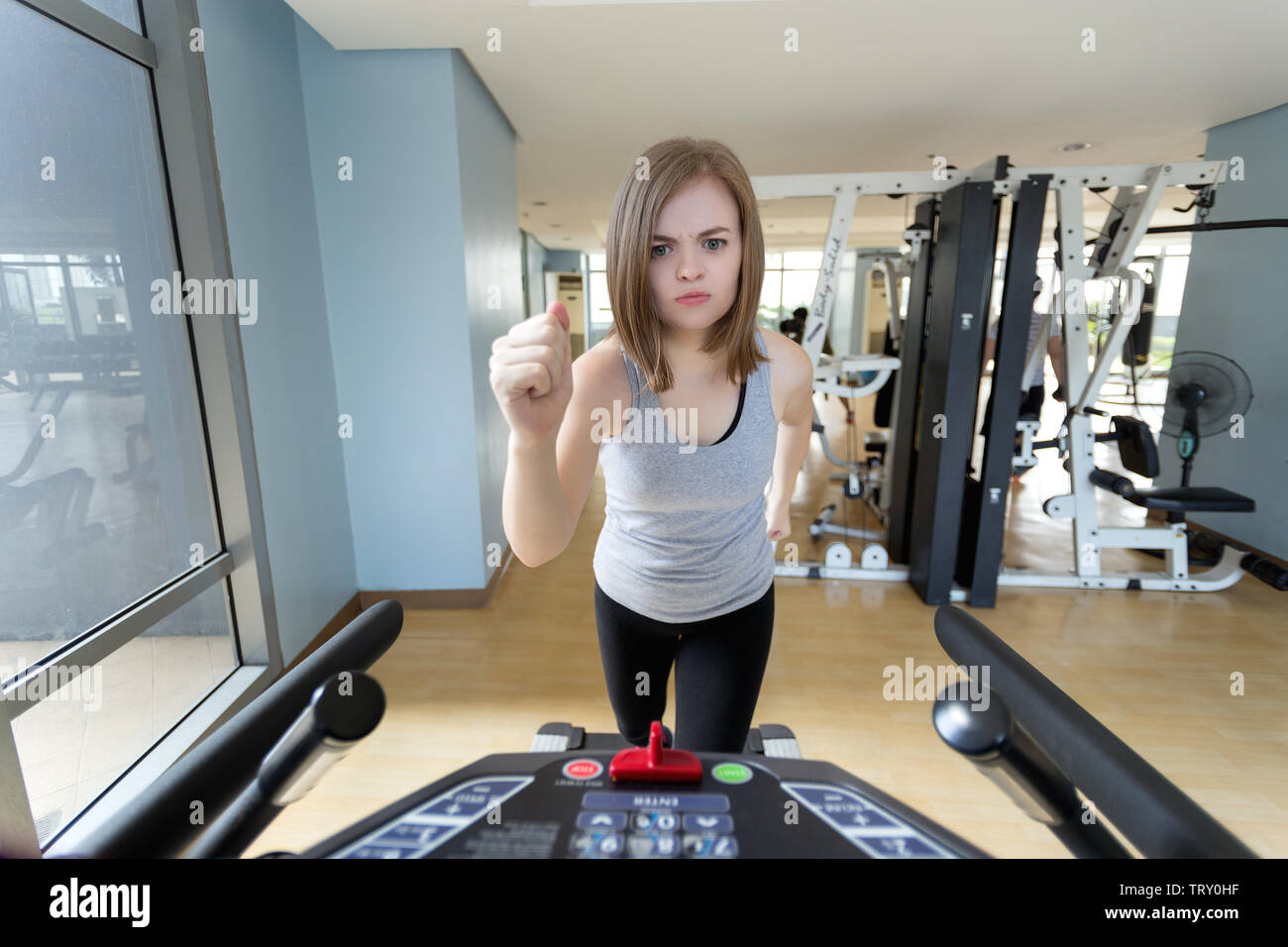 Joven mujer caucásica chica estéen marcha correr en la caminadora en el gimnasio, haciendo ejercicios de cardio Foto de stock