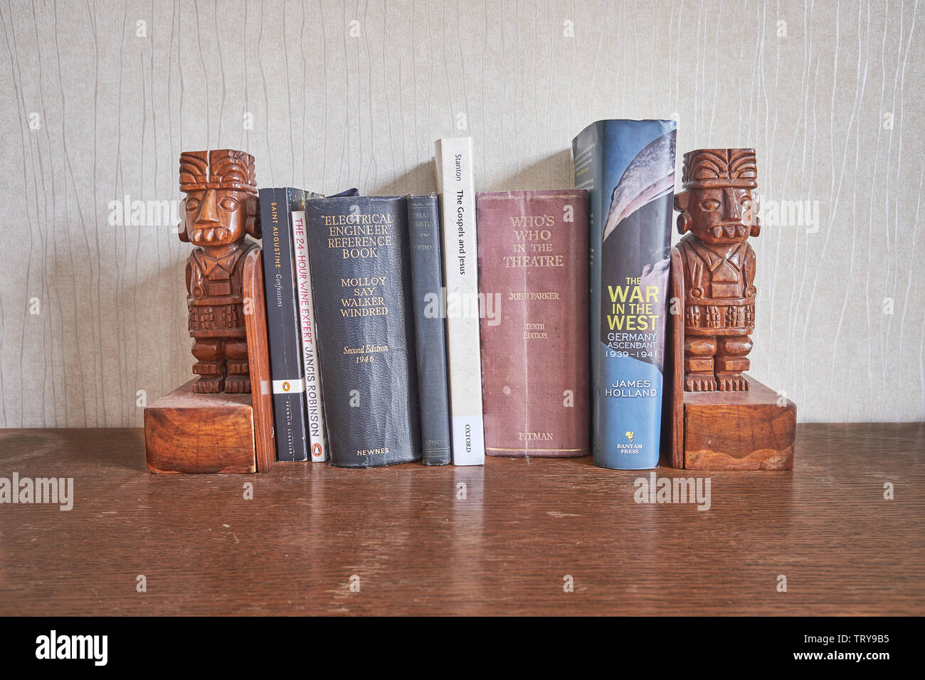 Mezcla de viejos y nuevos libros encajonados entre dos tallas de madera inca libro termina Foto de stock