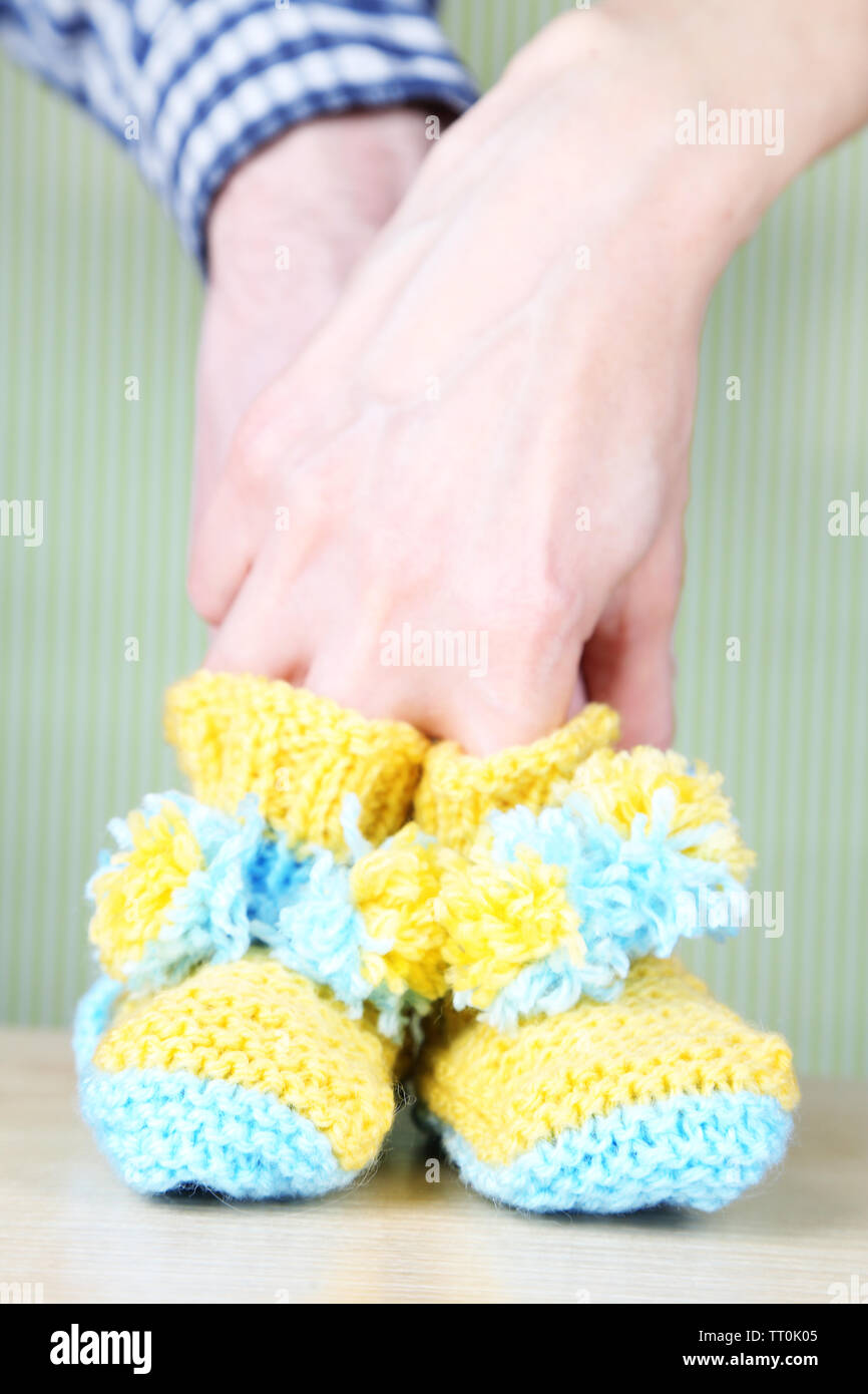 Manos con crochet botines para bebé, sobre fondo de color Fotografía de  stock - Alamy
