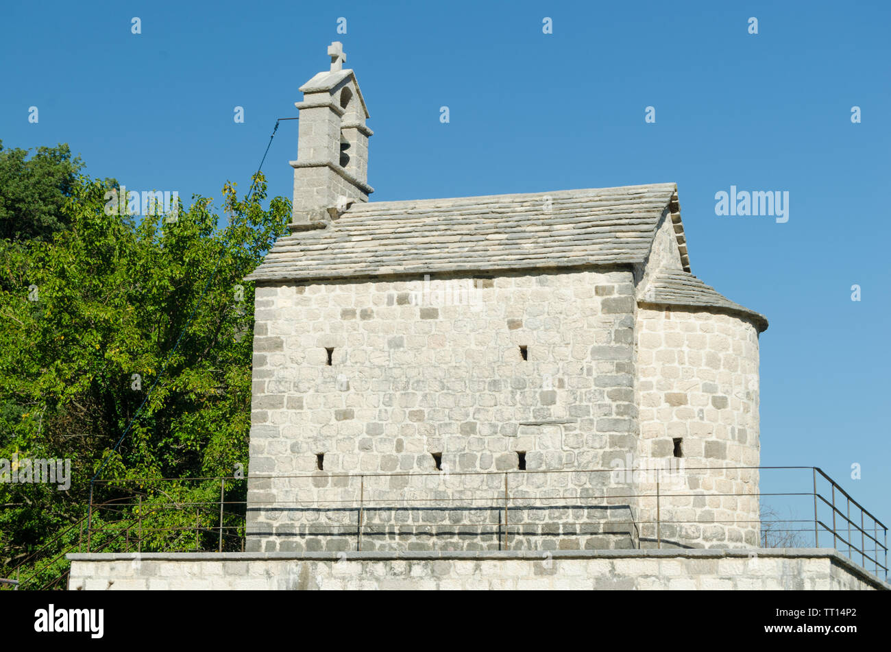 Antigua Iglesia con un campanario entre árboles verdes.Arquitectura y antigüedades. Foto de stock