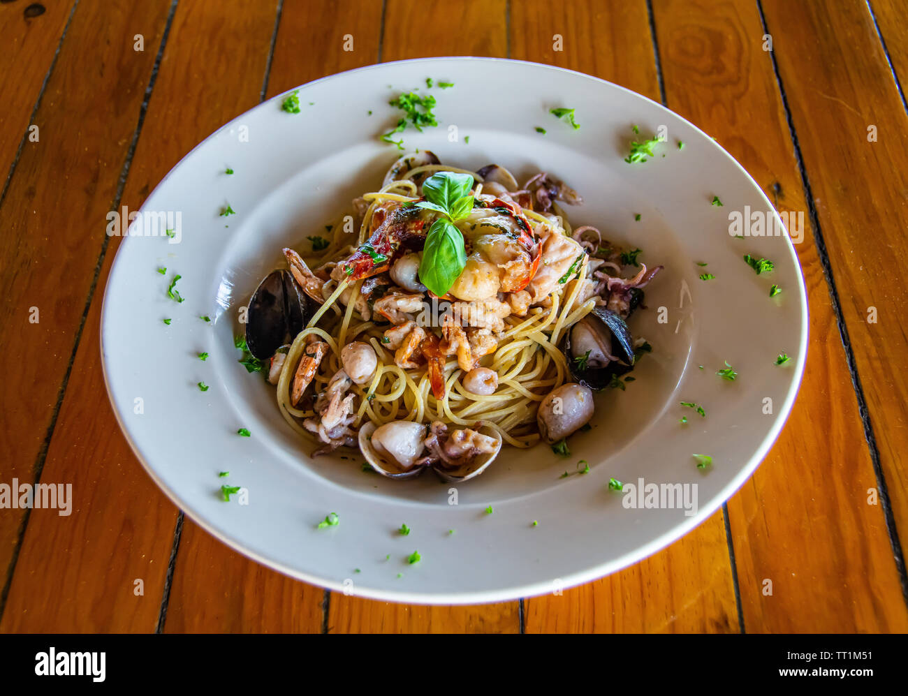 Mariscos pastas/spaghetti bowl en blanco sobre la mesa de madera Foto de stock