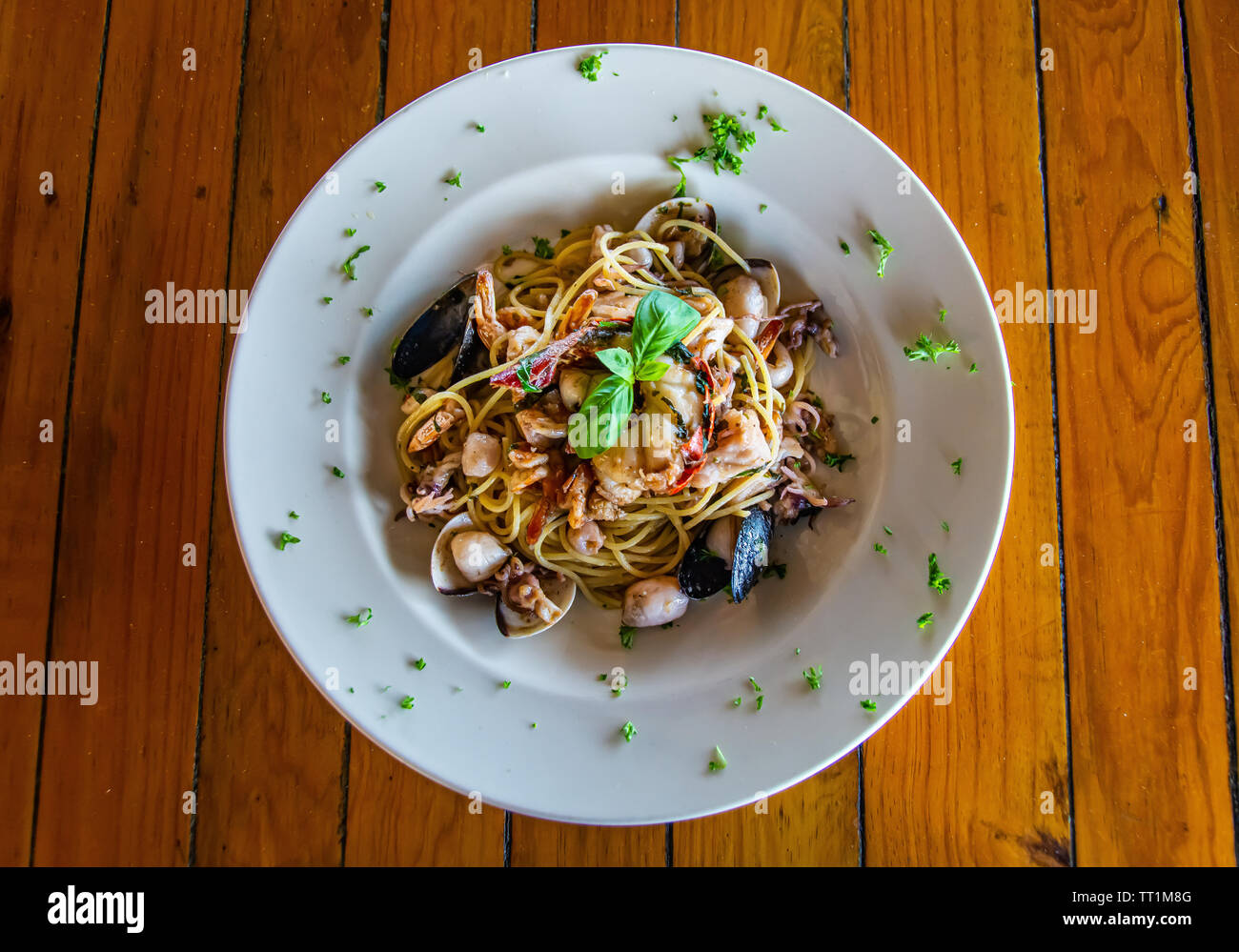 Mariscos pastas/spaghetti bowl en blanco sobre la mesa de madera Foto de stock