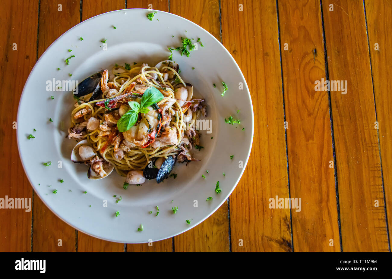 Mariscos pastas/spaghetti bowl en blanco sobre la mesa de madera Foto de stock