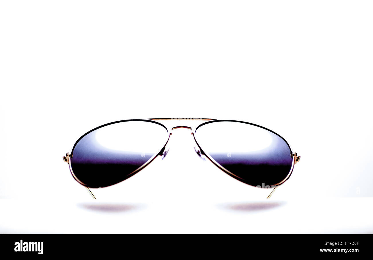 Un par de gafas de sol reflejados sobre un fondo blanco. Foto de stock