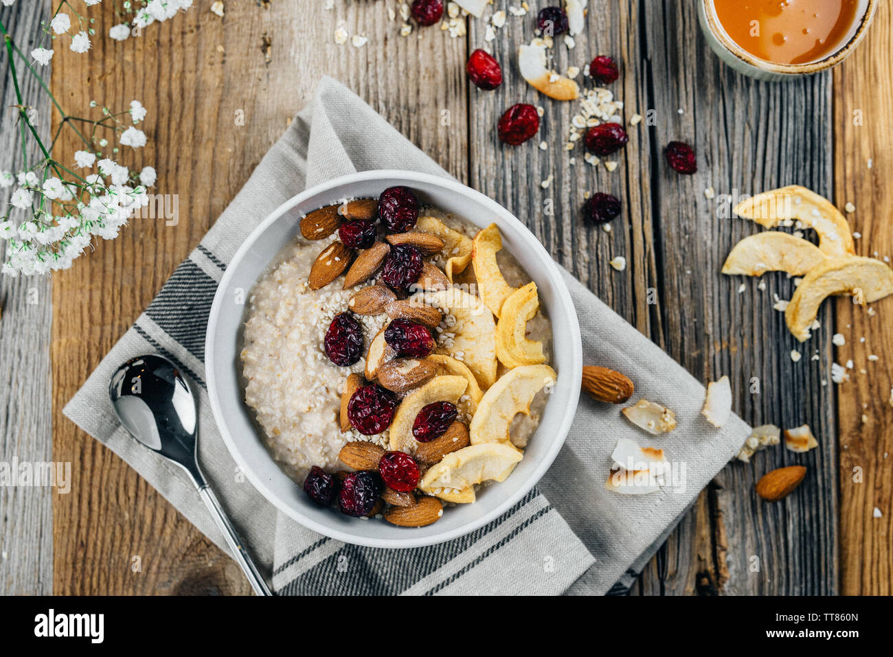 Una taza de avena bien decoradas con nueces, manzana, almendras y arándanos  sobre una tabla de madera Fotografía de stock - Alamy