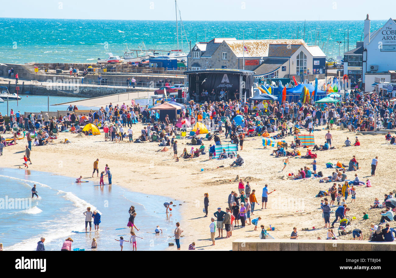 Lyme Regis, Dorset, Reino Unido. El 15 de junio, 2019. El clima del REINO UNIDO: Multitud de músicos y visitantes acuden a la playa, disfrutar de una Tarde de música como las guitarras anual en la playa evento arrancará en la playa en Lyme Regis en una gloriosa tarde de sol y cielo azul. La multitud es la estrella del espectáculo como guitarristas de todas las edades y capacidades se reúnen en la playa realizar juntos como 'banda' más grande de Gran Bretaña. Las personas disfrutar del relajado ambiente del festival antes de que se realice este año la canción elegida "En la playa". Crédito: Celia McMahon/Alamy Live News Foto de stock
