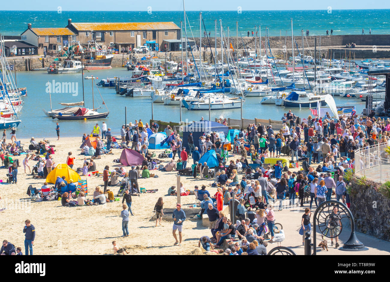 Lyme Regis, Dorset, Reino Unido. El 15 de junio de 2019. El clima del REINO UNIDO: Multitud de músicos y visitantes acuden a la playa, disfrutar de una Tarde de música como las guitarras anual en la playa evento arrancará en la playa en Lyme Regis en una gloriosa tarde de sol y cielo azul. La multitud es la estrella del espectáculo como guitarristas de todas las edades y capacidades se reúnen en la playa realizar juntos como 'banda' más grande de Gran Bretaña. Las personas disfrutar del relajado ambiente del festival antes de que se realice este año la canción elegida "En la playa". Crédito: Celia McMahon/Alamy Live News. Foto de stock