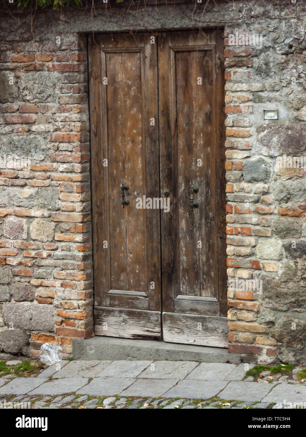 Detalle de la antigua puerta de planchas de madera de la casa rural, con  piezas de fijación de hierro, Italia Fotografía de stock - Alamy