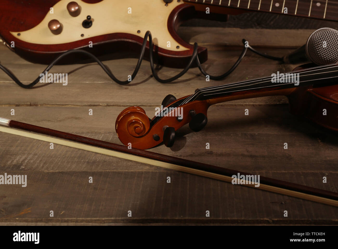 Guitarra eléctrica, violín, arco y micrófono en el fondo de madera  Fotografía de stock - Alamy