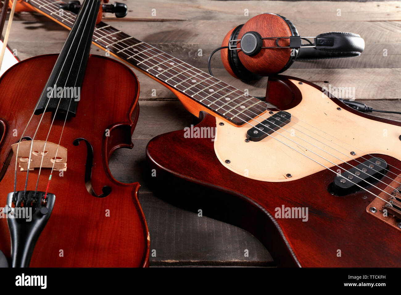 Guitarra eléctrica, violín, y los auriculares sobre fondo de madera  Fotografía de stock - Alamy