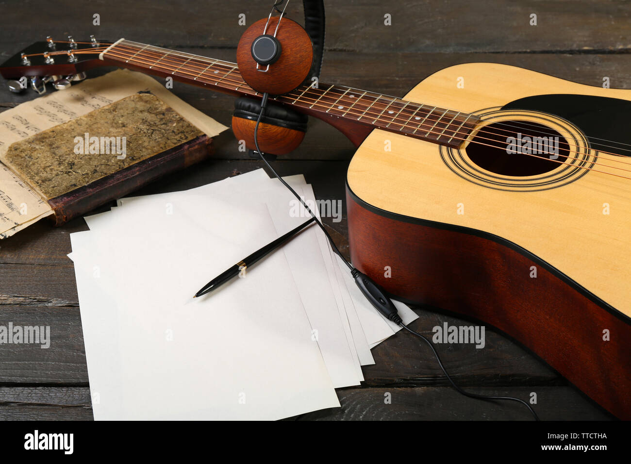Guitarra acústica, auriculares, notas musicales y libros blancos sobre  fondo de madera Fotografía de stock - Alamy