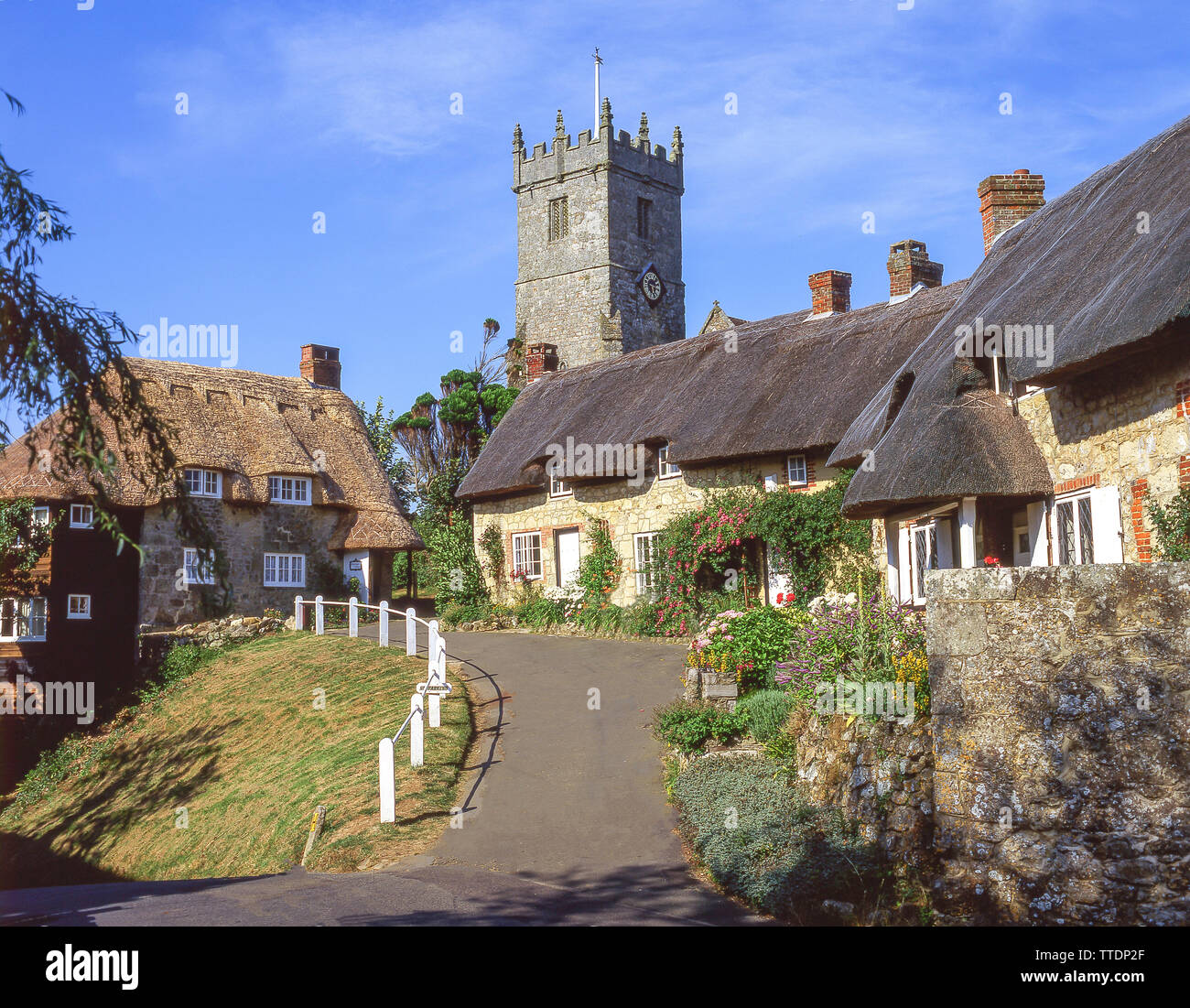 Cabañas con techo de paja y la Iglesia de Todos Los Santos, Godshill, la Isla de Wight, Inglaterra, Reino Unido Foto de stock