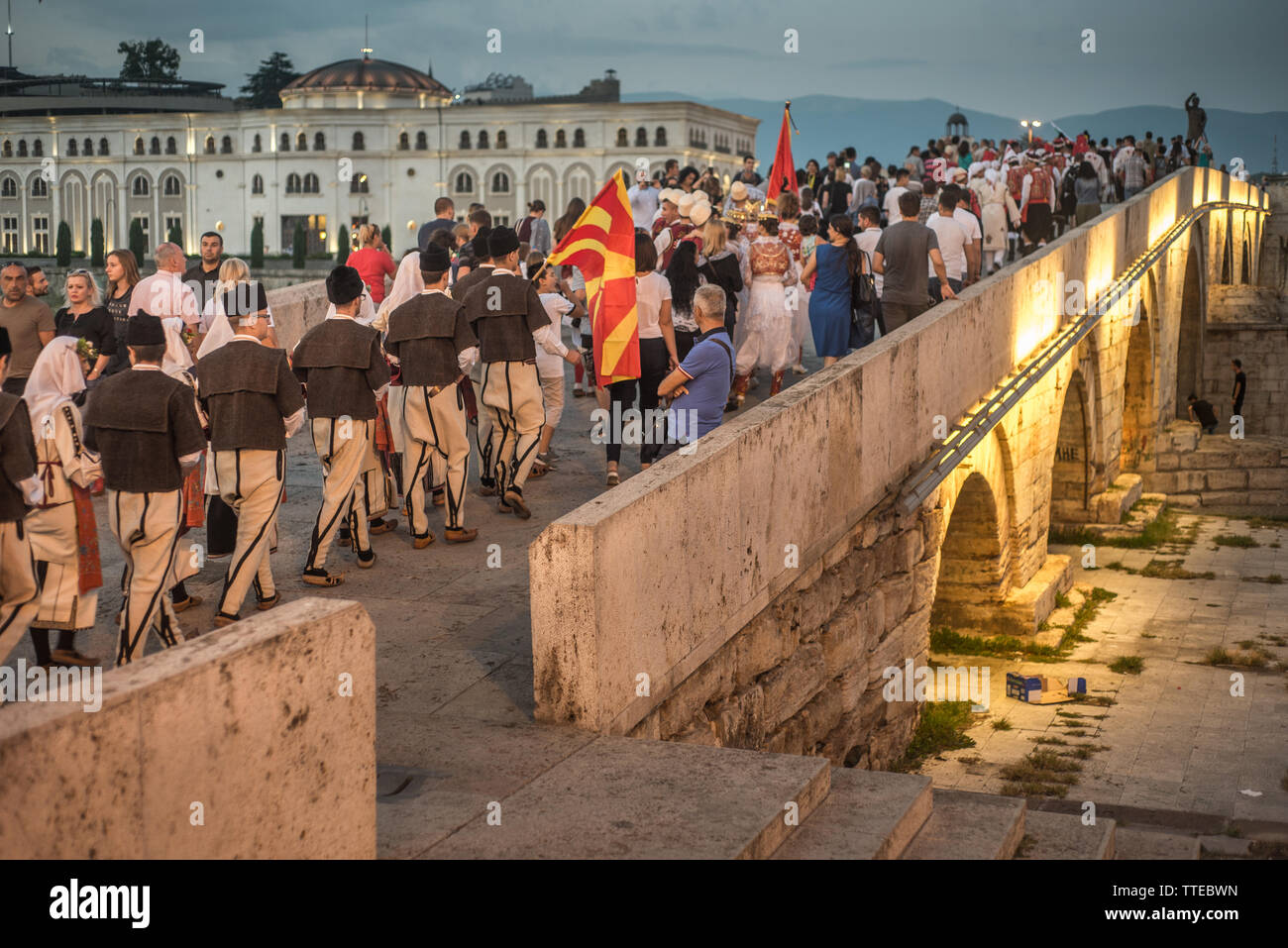 SKOPJE, macedonia de agosto 28,2018: los participantes del Festival Internacional de Música & Folk-Dance o Skopje Fest cruzar el puente de piedra en una procesión. Foto de stock