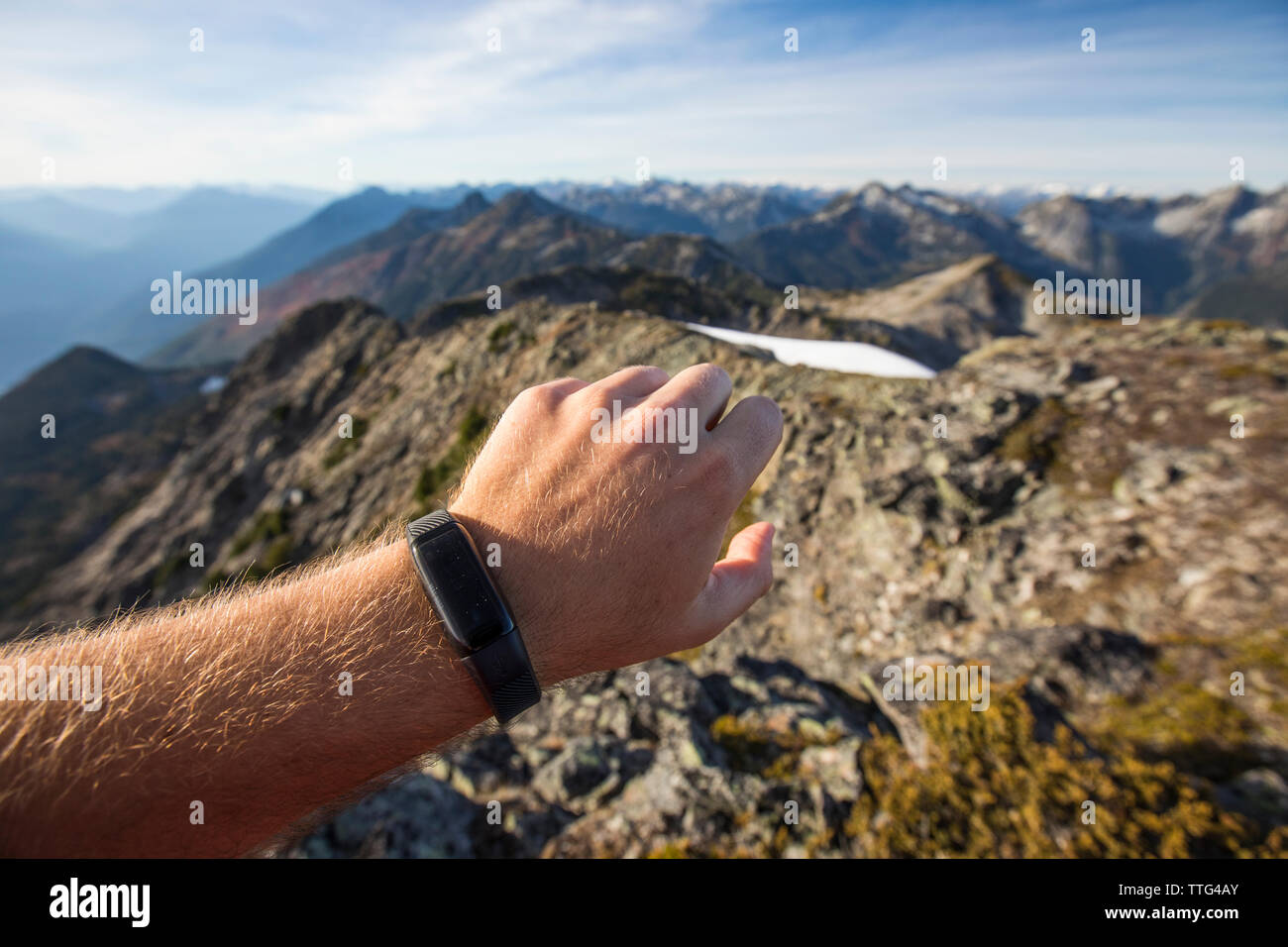 Trail Runner comprueba su aptitud mirar mientras en una cresta de la montaña. Foto de stock