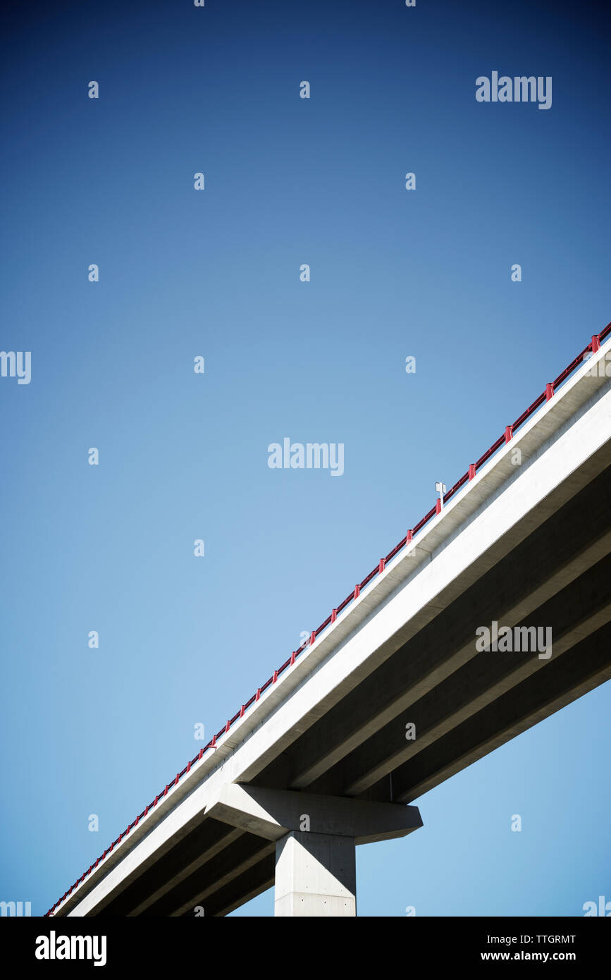 Ángulo de visión baja de puente contra el azul claro del cielo durante el día soleado Foto de stock