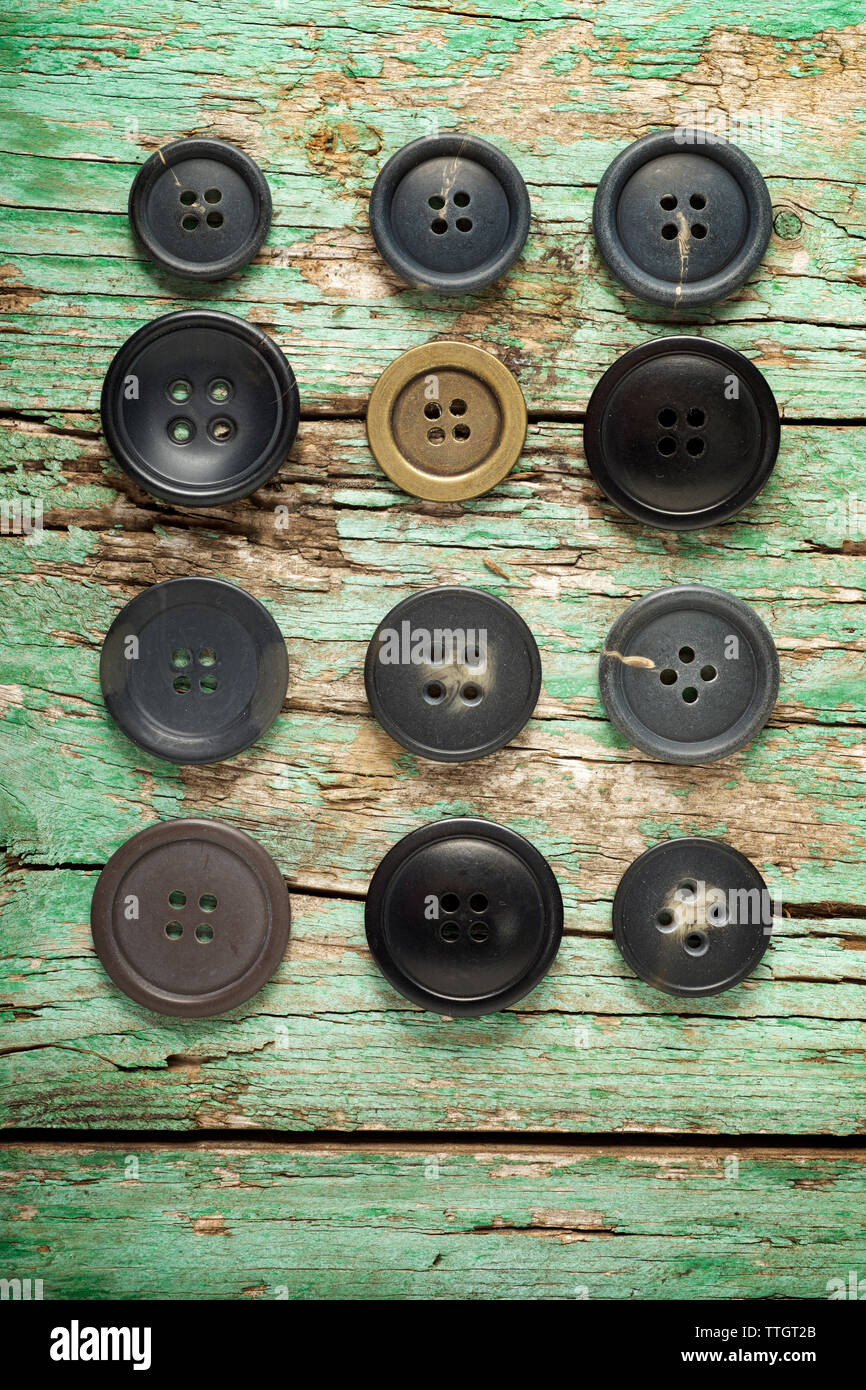 Vista aérea de botones organizados en mesa de madera antigua Foto de stock