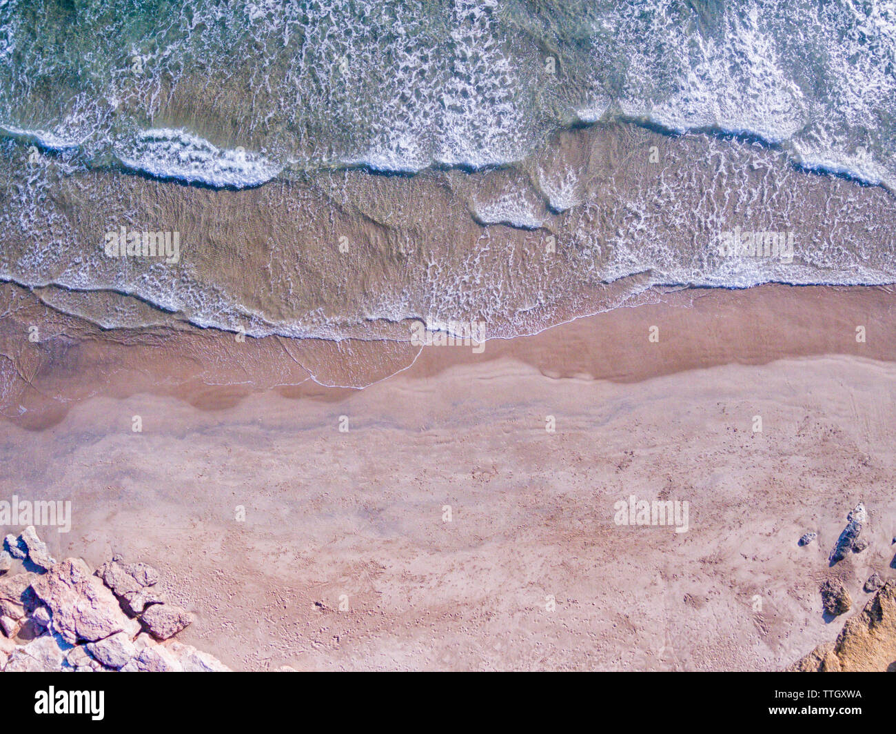 Una vista aérea de las olas rompiendo contra la playa Foto de stock