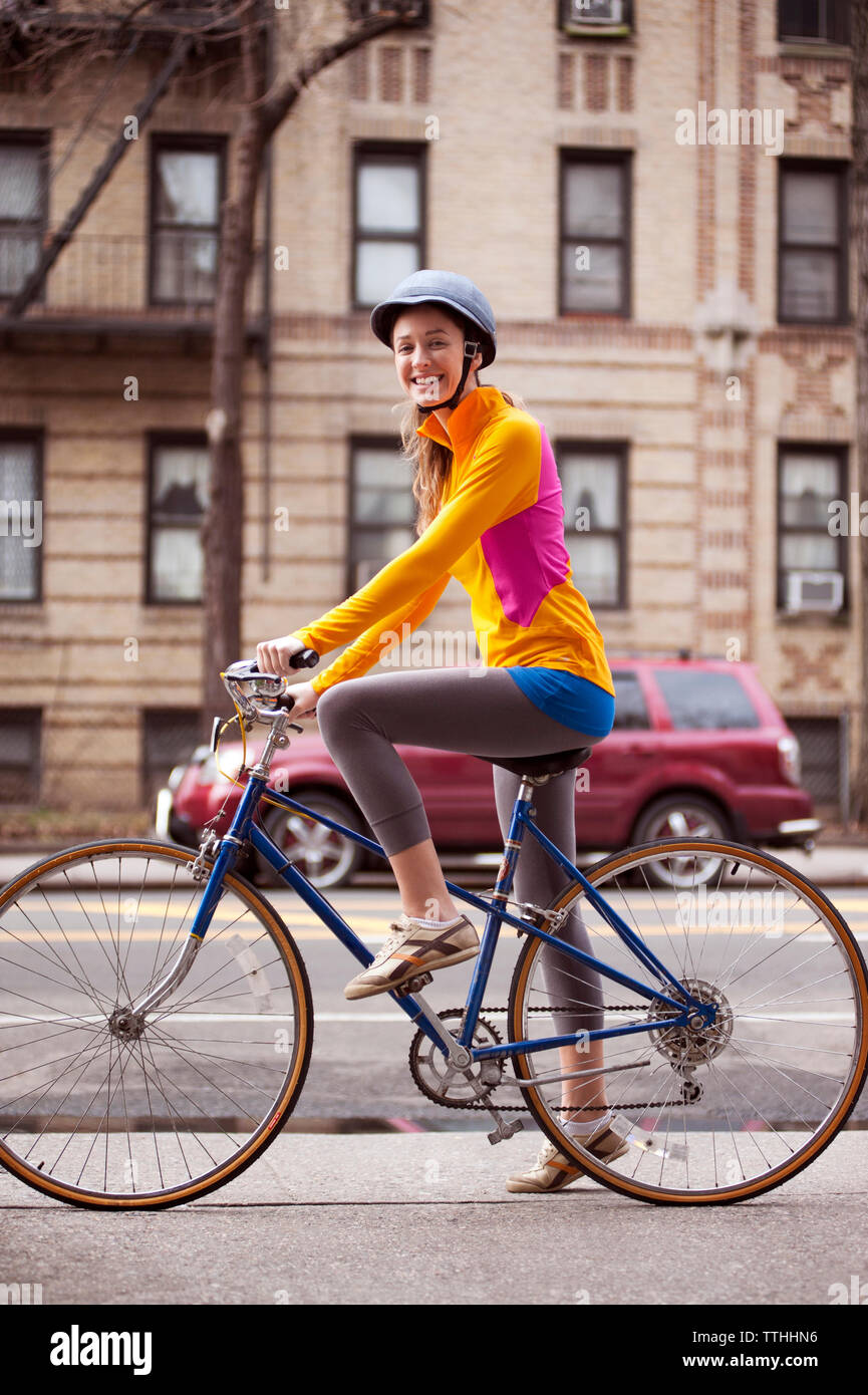 Retrato de mujer ciclista con bicicleta sobre la acera Foto de stock