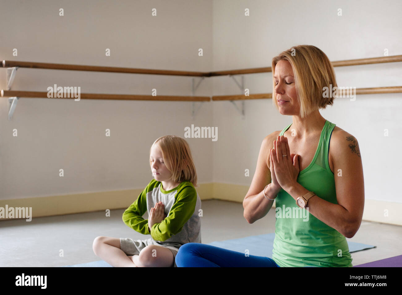 Boy ejerciendo con instructor en clase de yoga Foto de stock