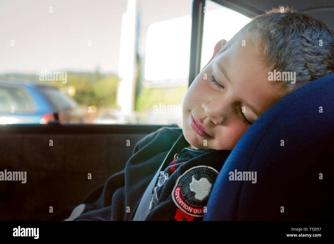 Chico lindo durmiendo en el coche Foto de stock