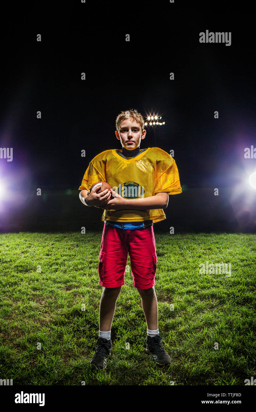 Retrato del jugador con balón de fútbol americano en el campo Foto de stock