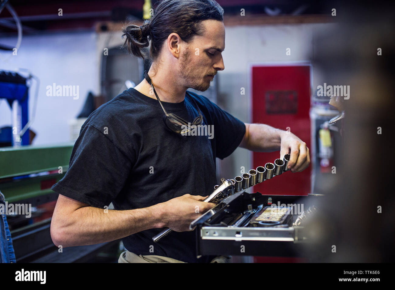Herramienta mano sostenedora mecánico en el taller de reparación de automóviles Foto de stock