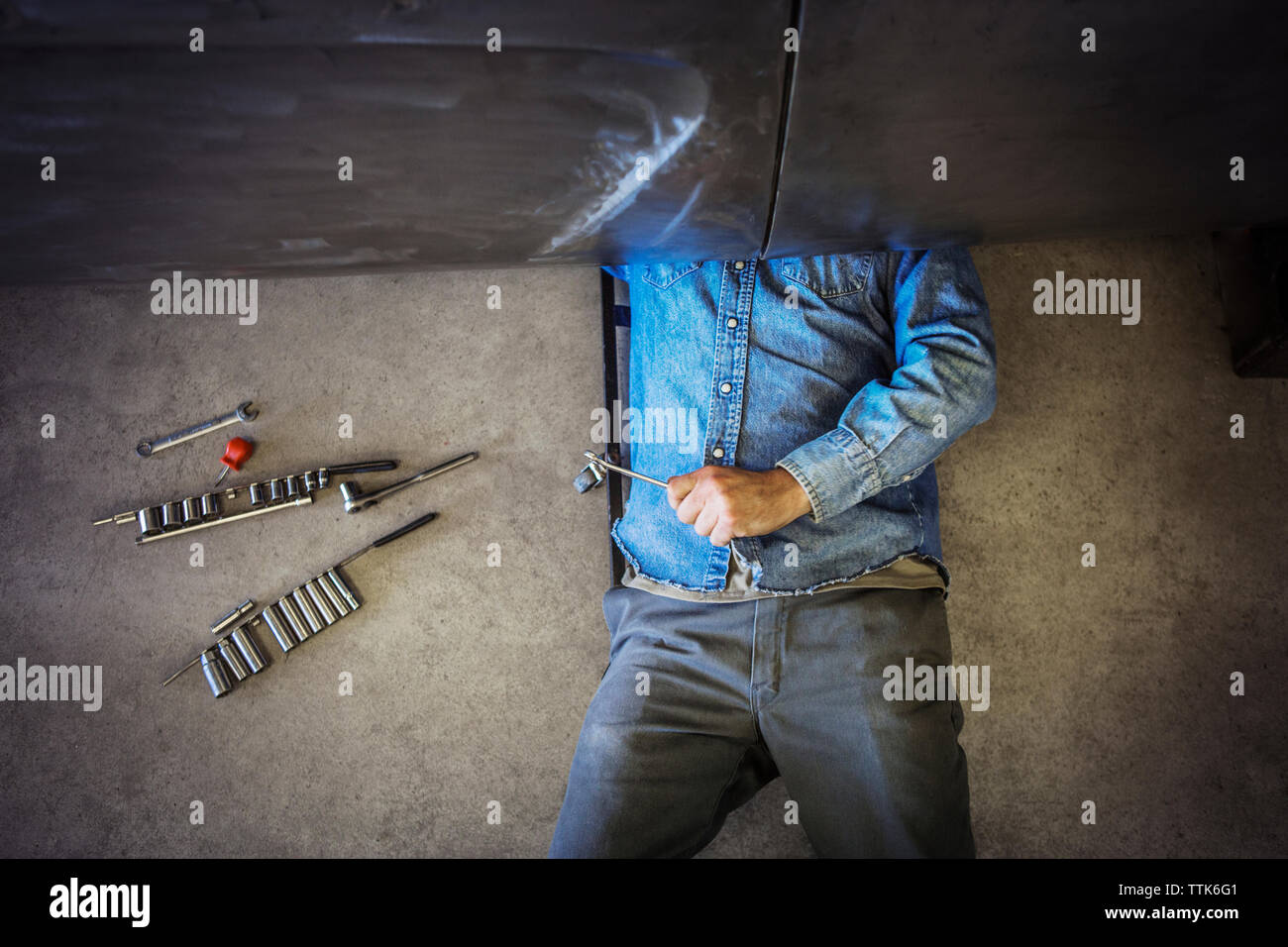 Mechanic lying working under car fotografías e imágenes de alta resolución  - Alamy