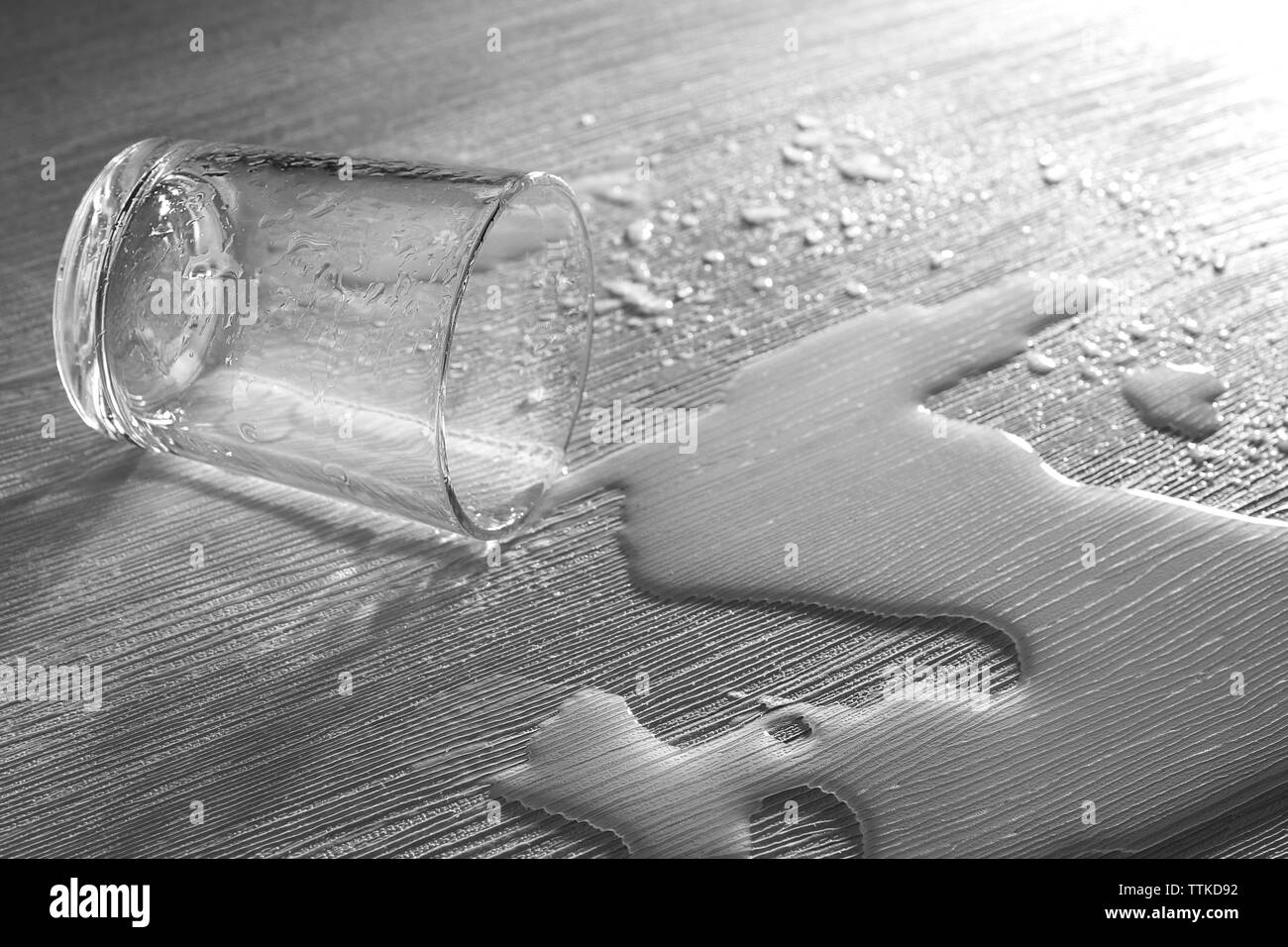 Vaso de agua derramado sobre fondo de textura Foto de stock