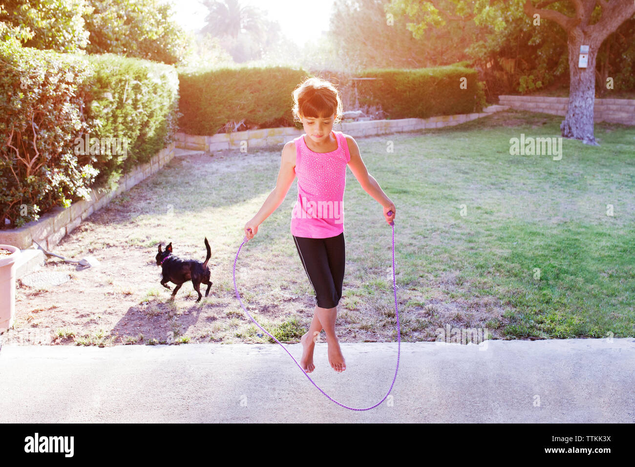 Chica saltando con cuerda en campo Foto de stock