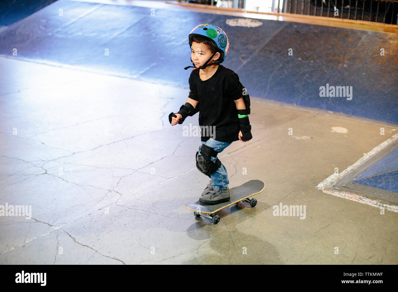 Patinador de skateboard kid en un indoor skatepark Foto de stock