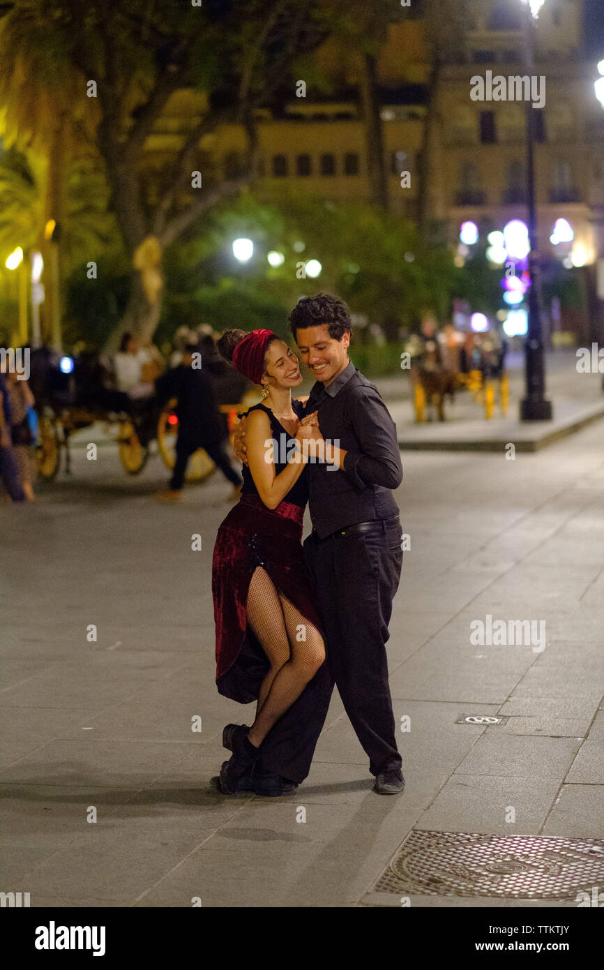 Un baile de pareja en las calles de Sevilla Foto de stock