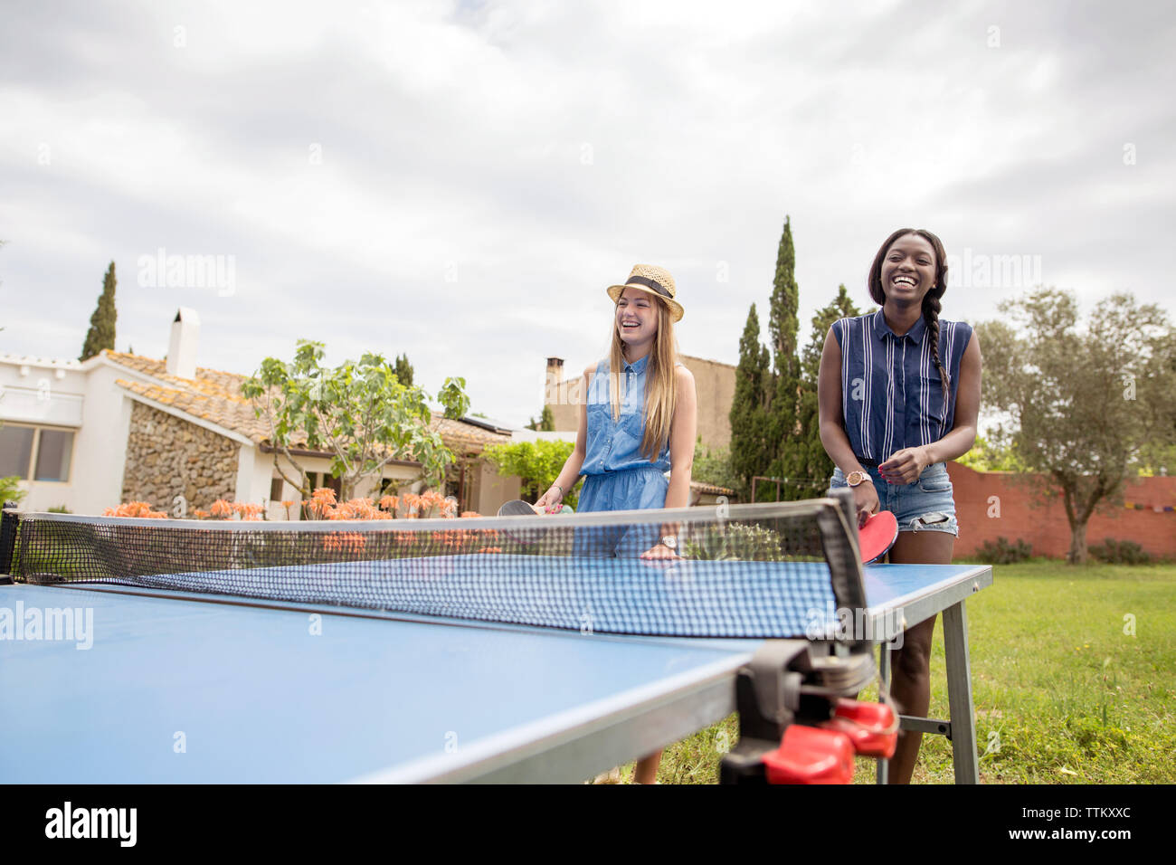 Las mujeres feliz jugando al tenis de mesa en el patio Fotografía de stock  - Alamy