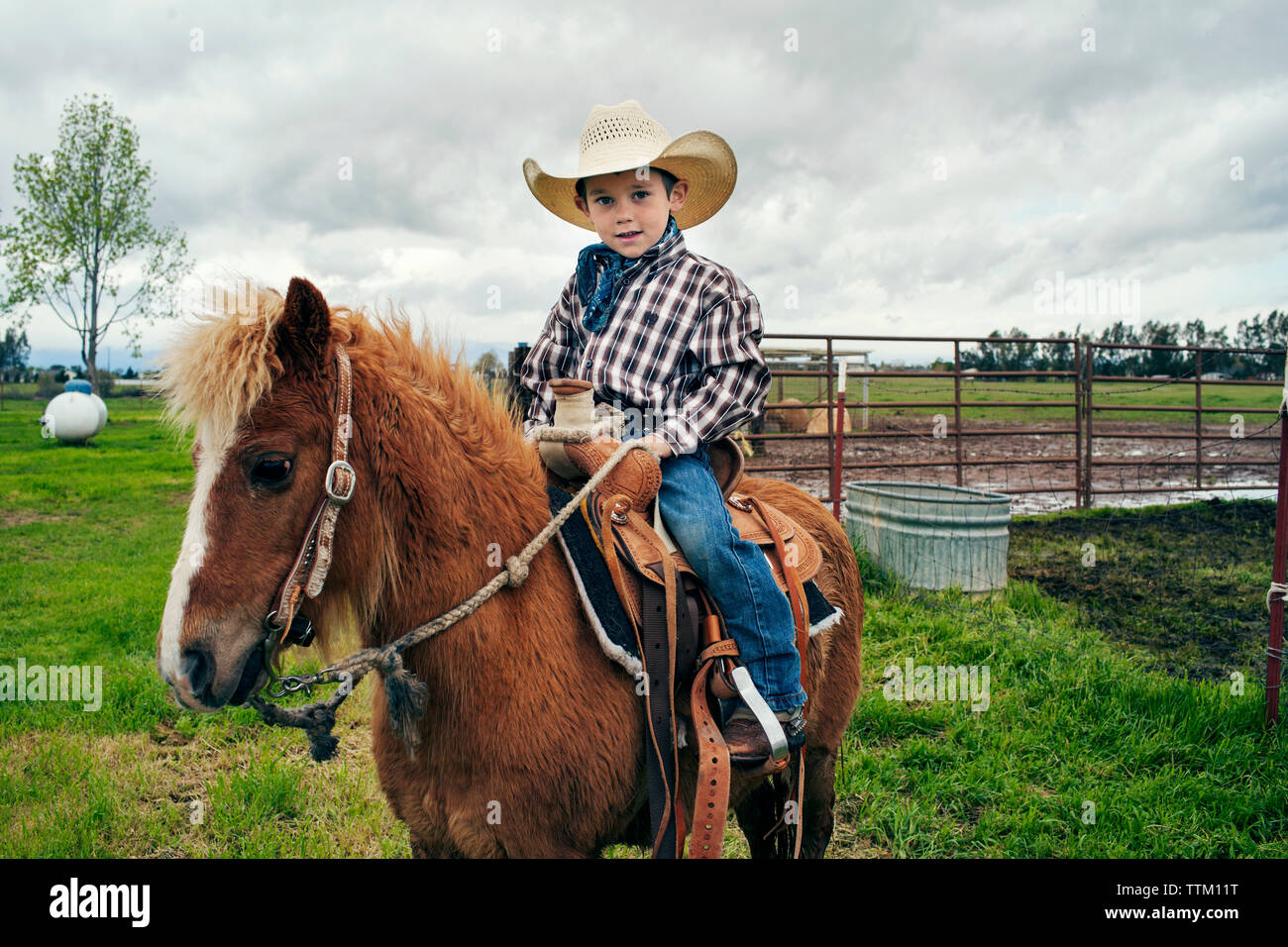 Retrato de lindo cowboy a caballo en el rancho Foto de stock