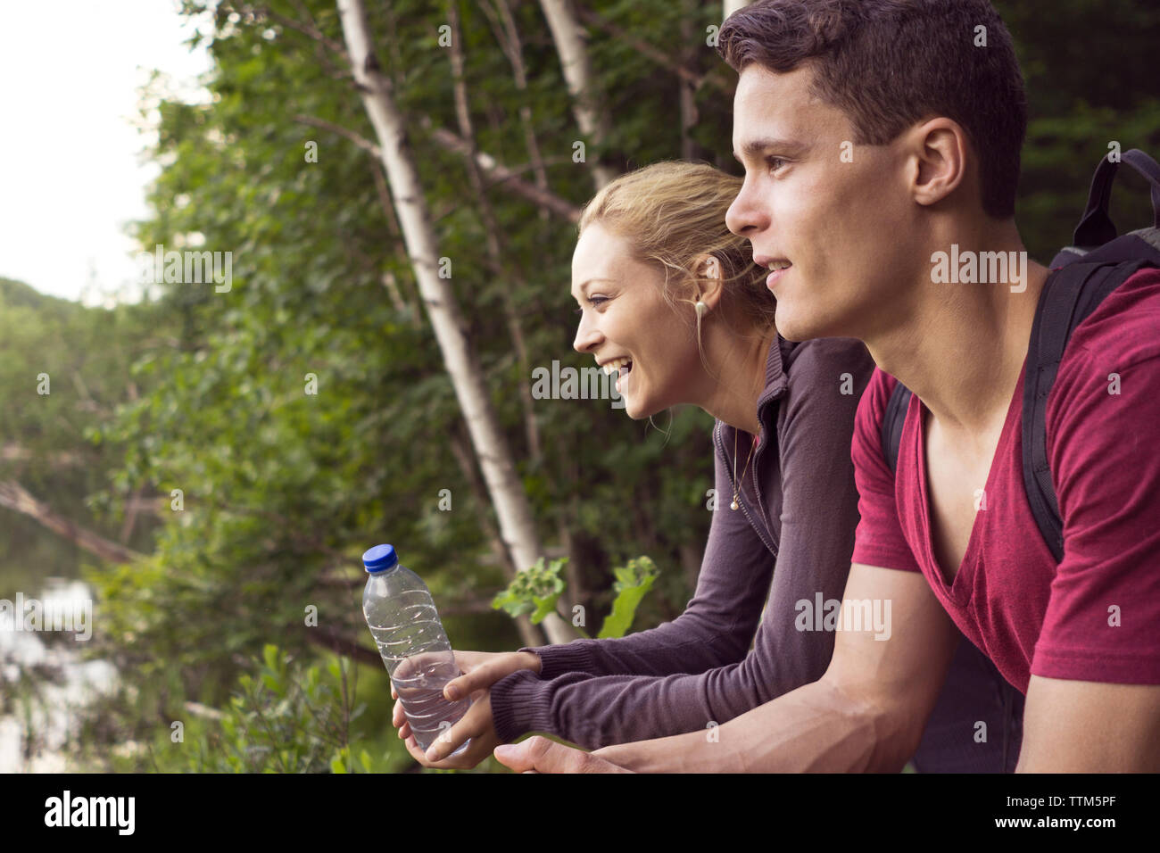 Adulto joven pareja parando para disfrutar el aire fresco durante la caminata a través del bosque en el este de Canadá Foto de stock