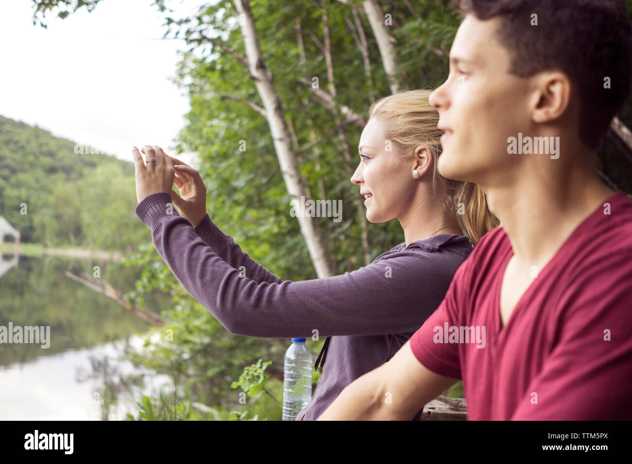 Amigos tomando fotografías y recuerdos durante la caminata al lago de montaña en el este de Canadá Foto de stock