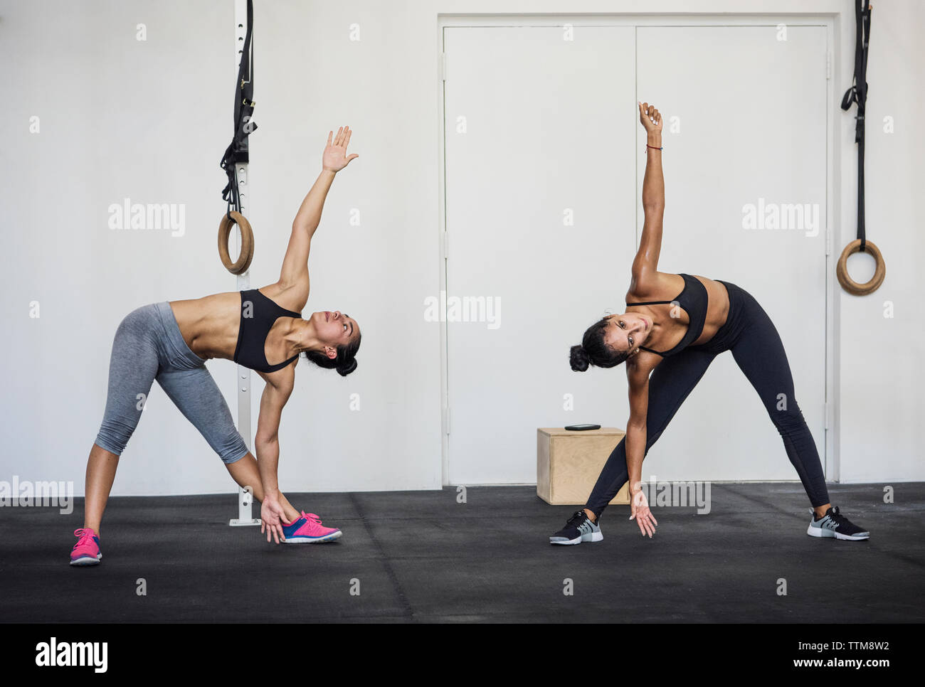 Las mujeres atletas haciendo ejercicios de calentamiento en el gimnasio  crossfit Fotografía de stock - Alamy