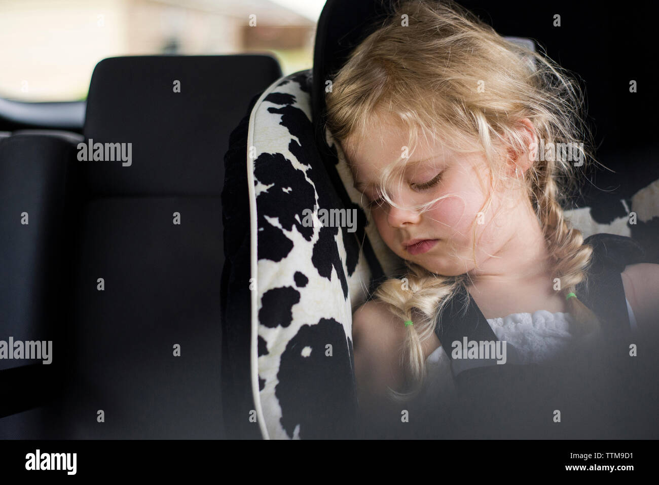 Chica cansada durmiendo en el coche Foto de stock