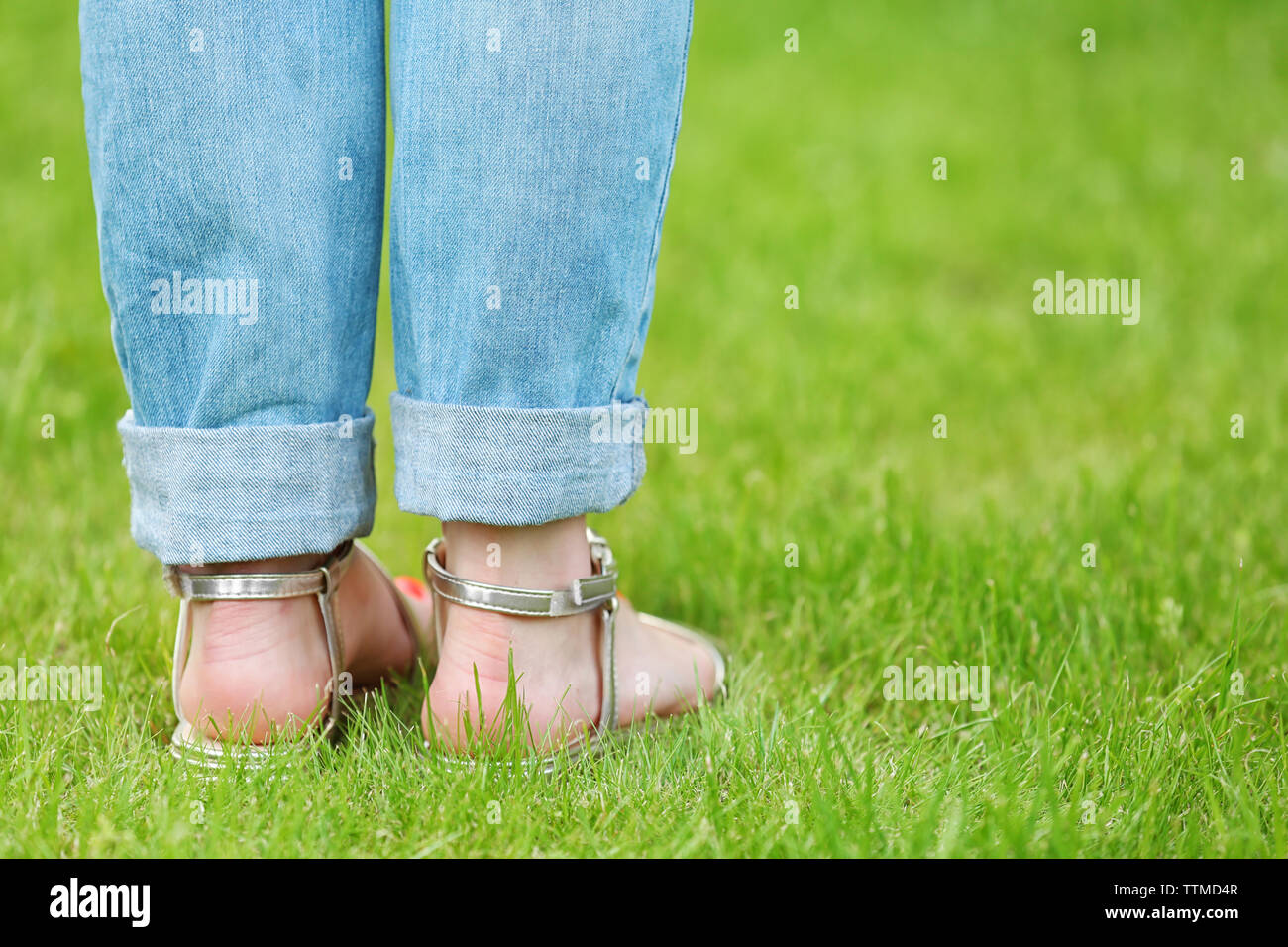 Los pies femeninos en sandalias en pasto verde Fotografía de stock - Alamy